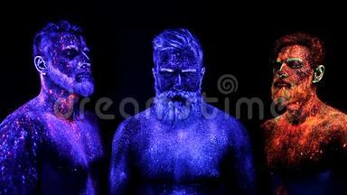 三个留胡子的男人在紫外线粉末中站立静止